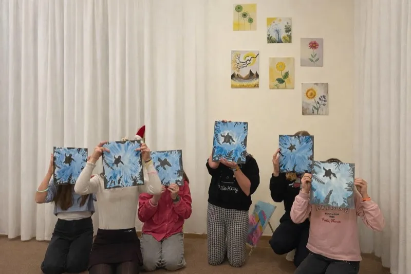 Grupa djece ponosno pokazuje svoje gotove slike